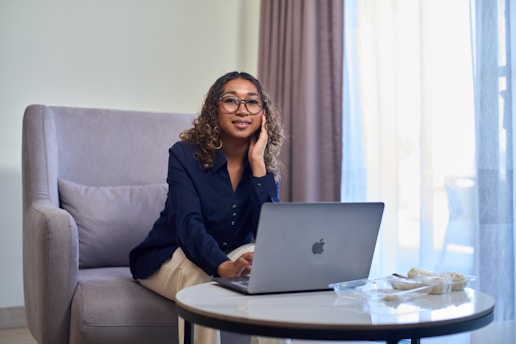 Woman working on laptop in a comfortable chair.