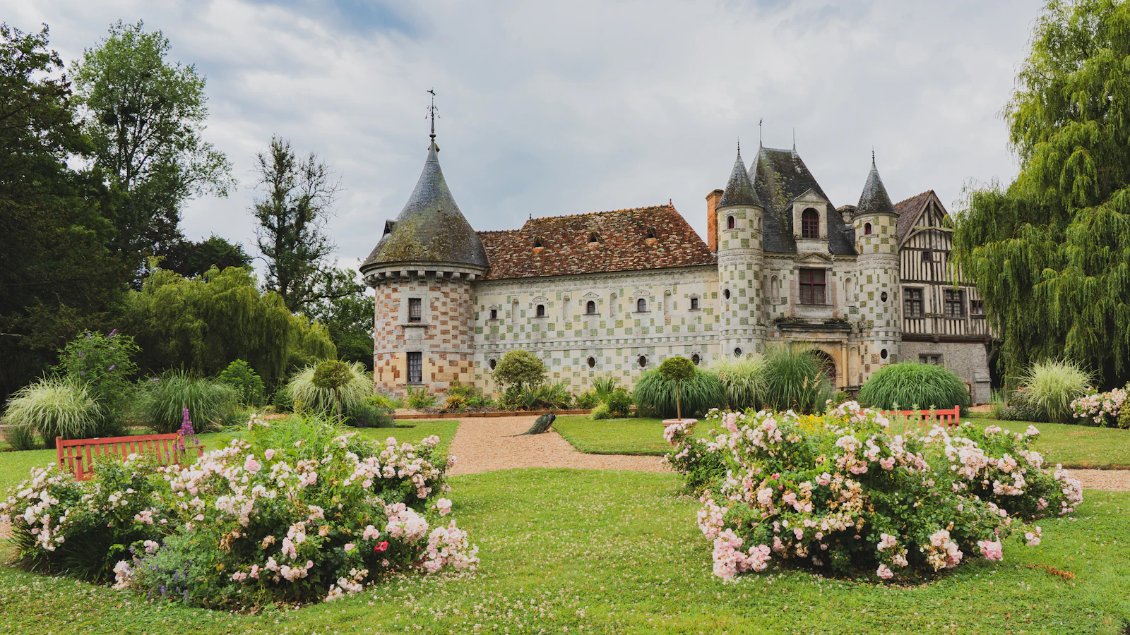 The checkerboard Château de Saint-Germain-de-Livet among rose gardens in the Normandy countryside