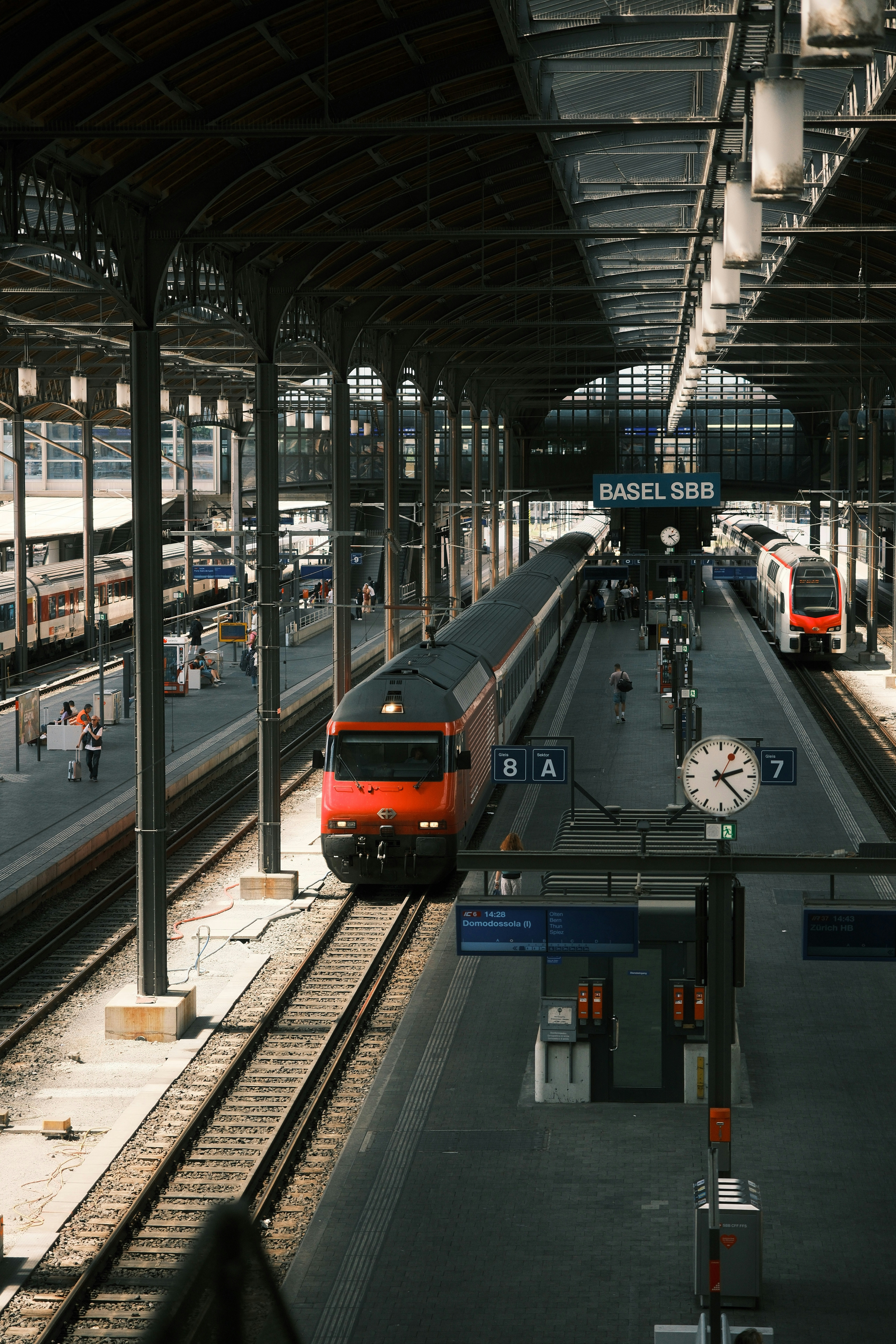 Red train at a busy basel sbb train station.