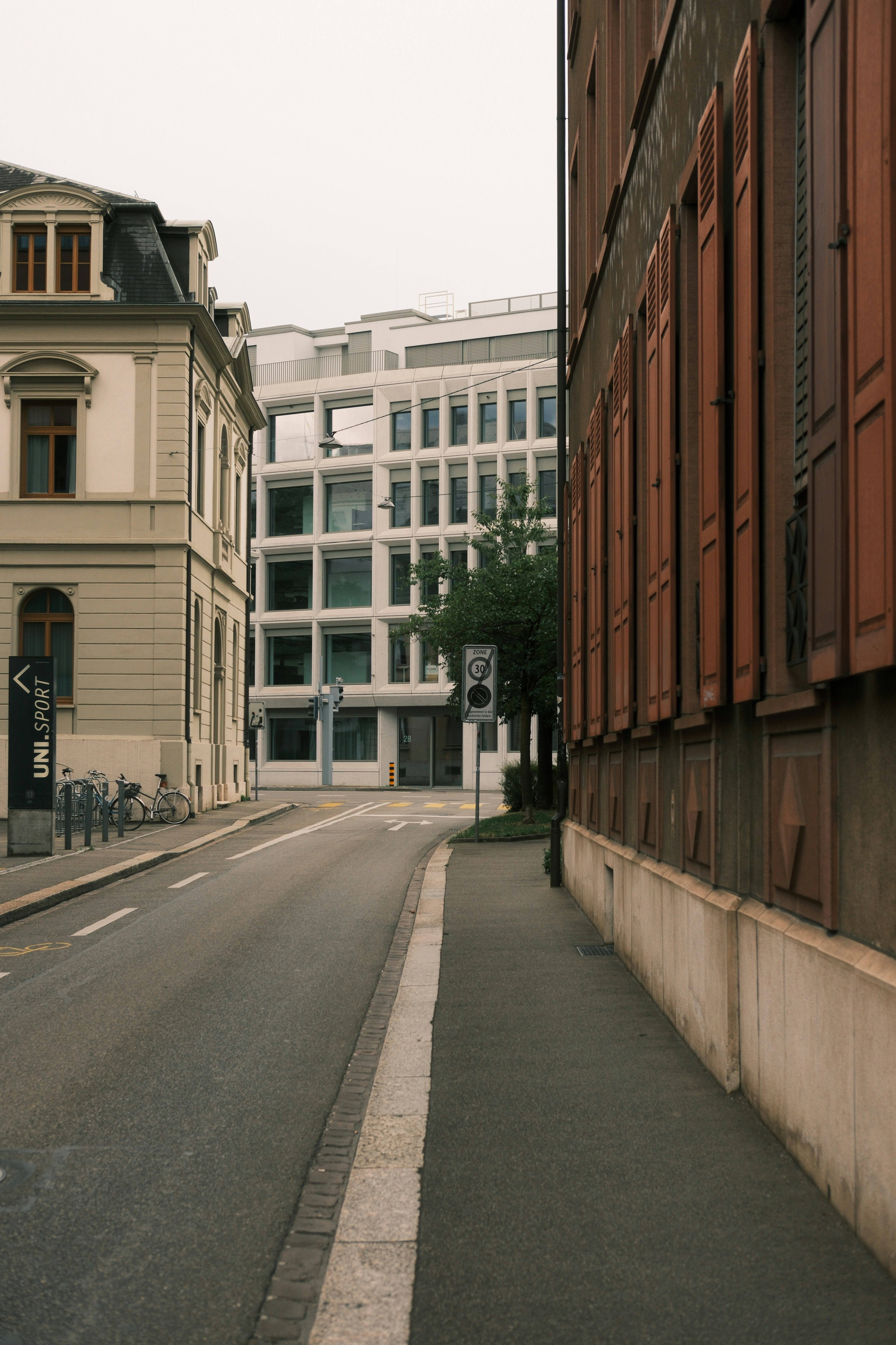 Street with buildings and a modern white structure.