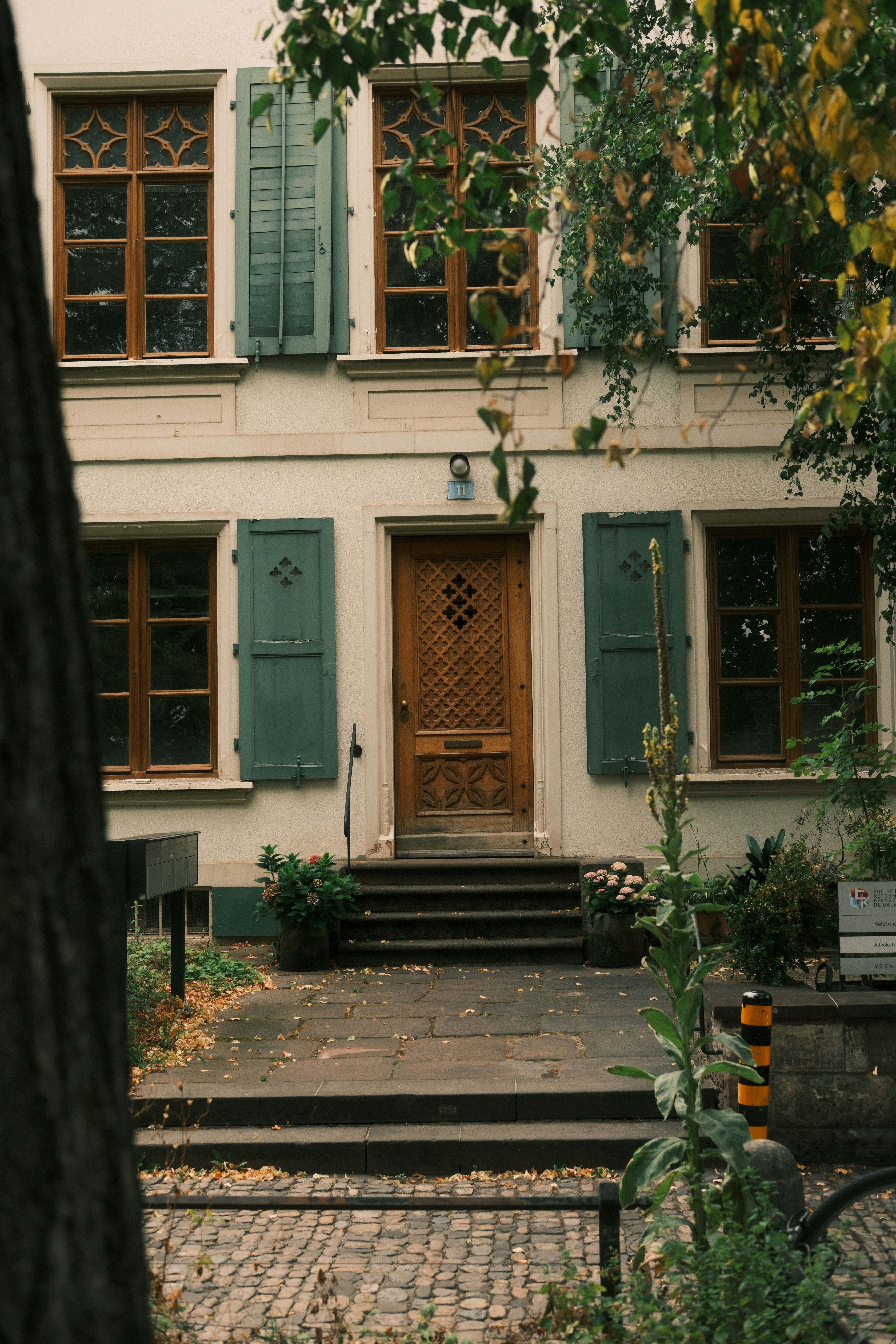 Ornate wooden door on a cream-colored building.