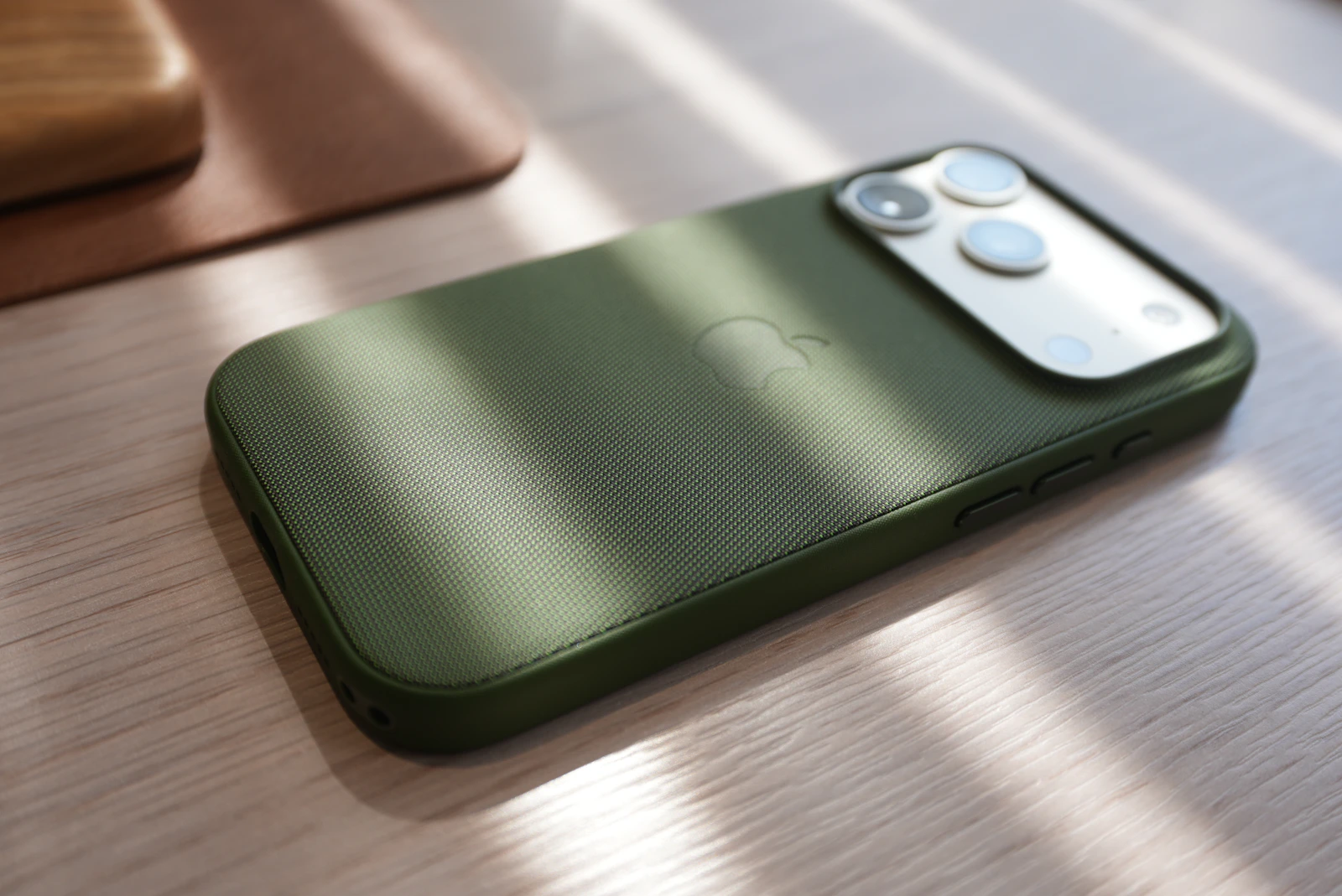 Green protective smartphone case photographed on a wooden surface