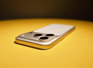 Smartphone with three cameras on yellow surface
