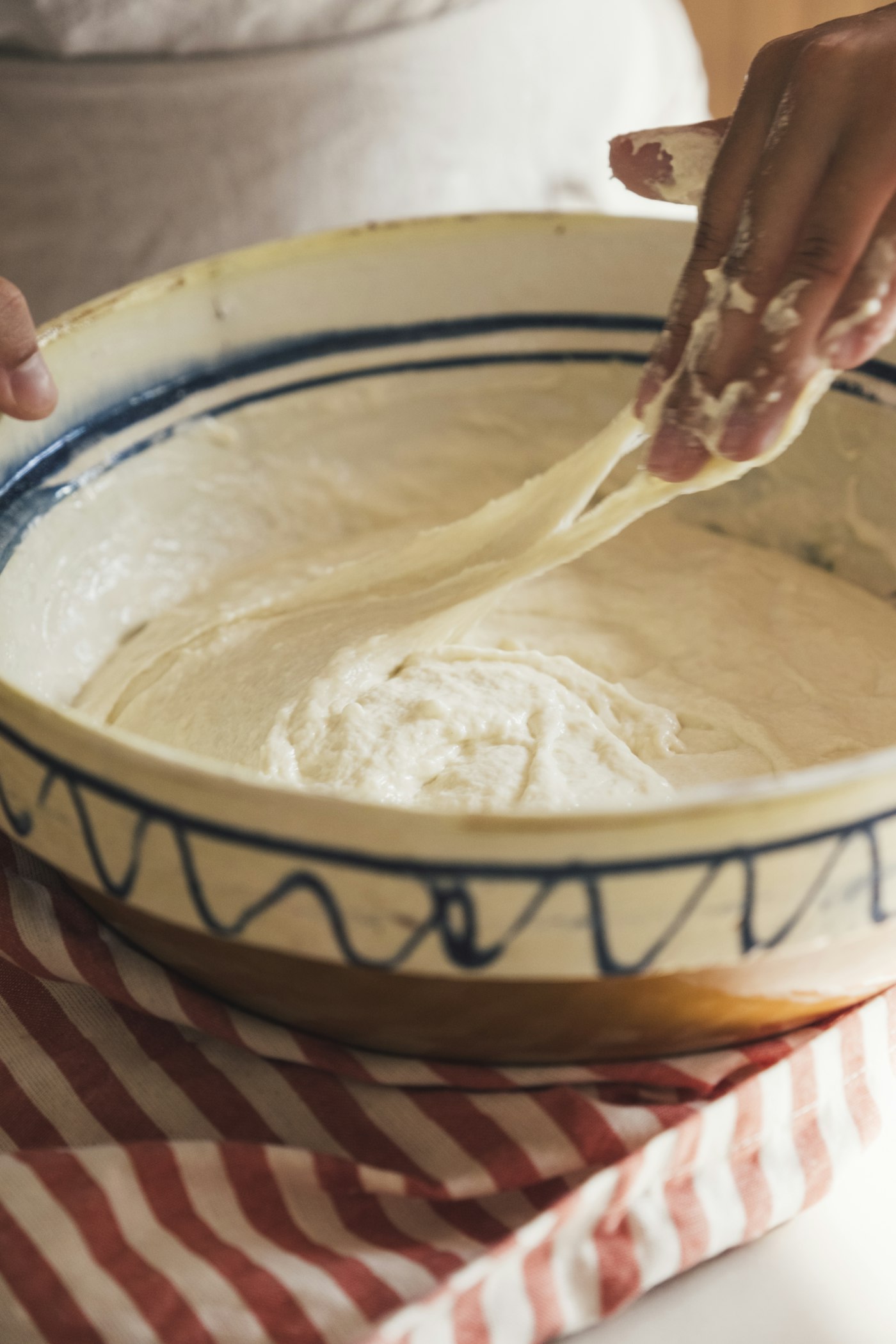 Placeholder: hands preparing body butter in a kitchen