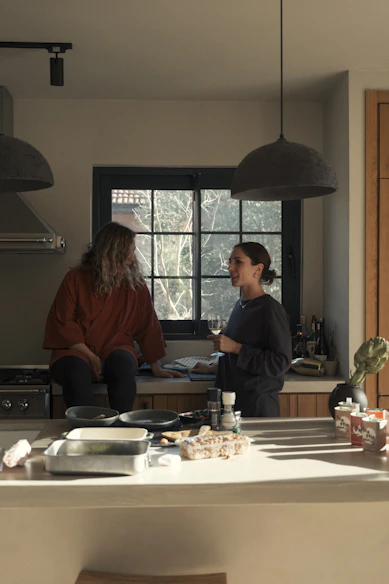 Two women talking in a modern kitchen.