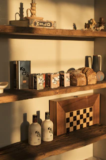 Bottles of olive oil and loaves of bread on shelves.