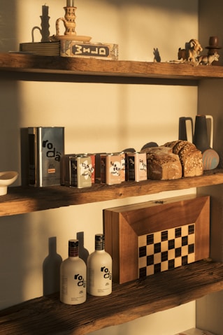 Bottles of olive oil and loaves of bread on shelves.