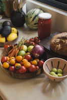Fresh produce including tomatoes, carrots, and avocados on a counter.
