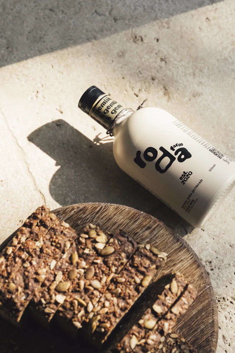 Bottle of olive oil beside sliced artisan bread