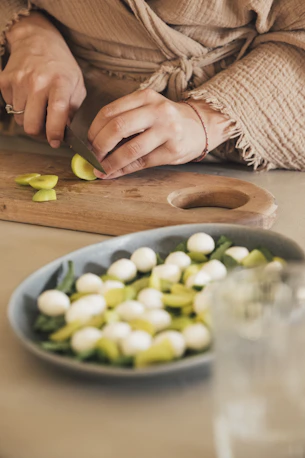 A person slicing green fruit for a salad