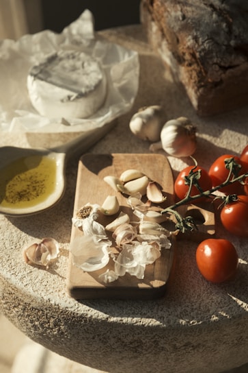 Fresh ingredients for cooking: garlic, tomatoes, cheese, bread, olive oil.