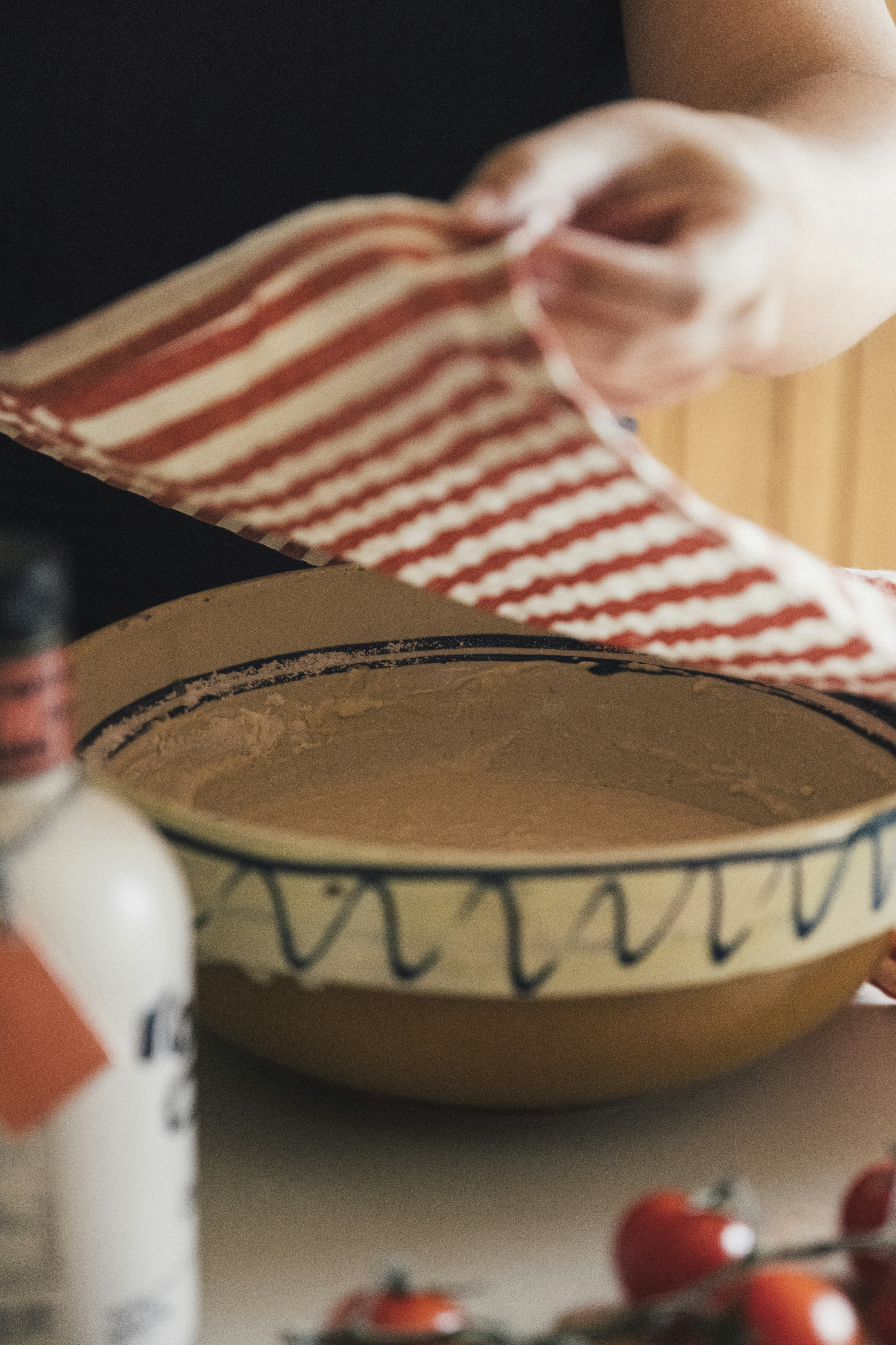 Hands covering bowl with striped cloth