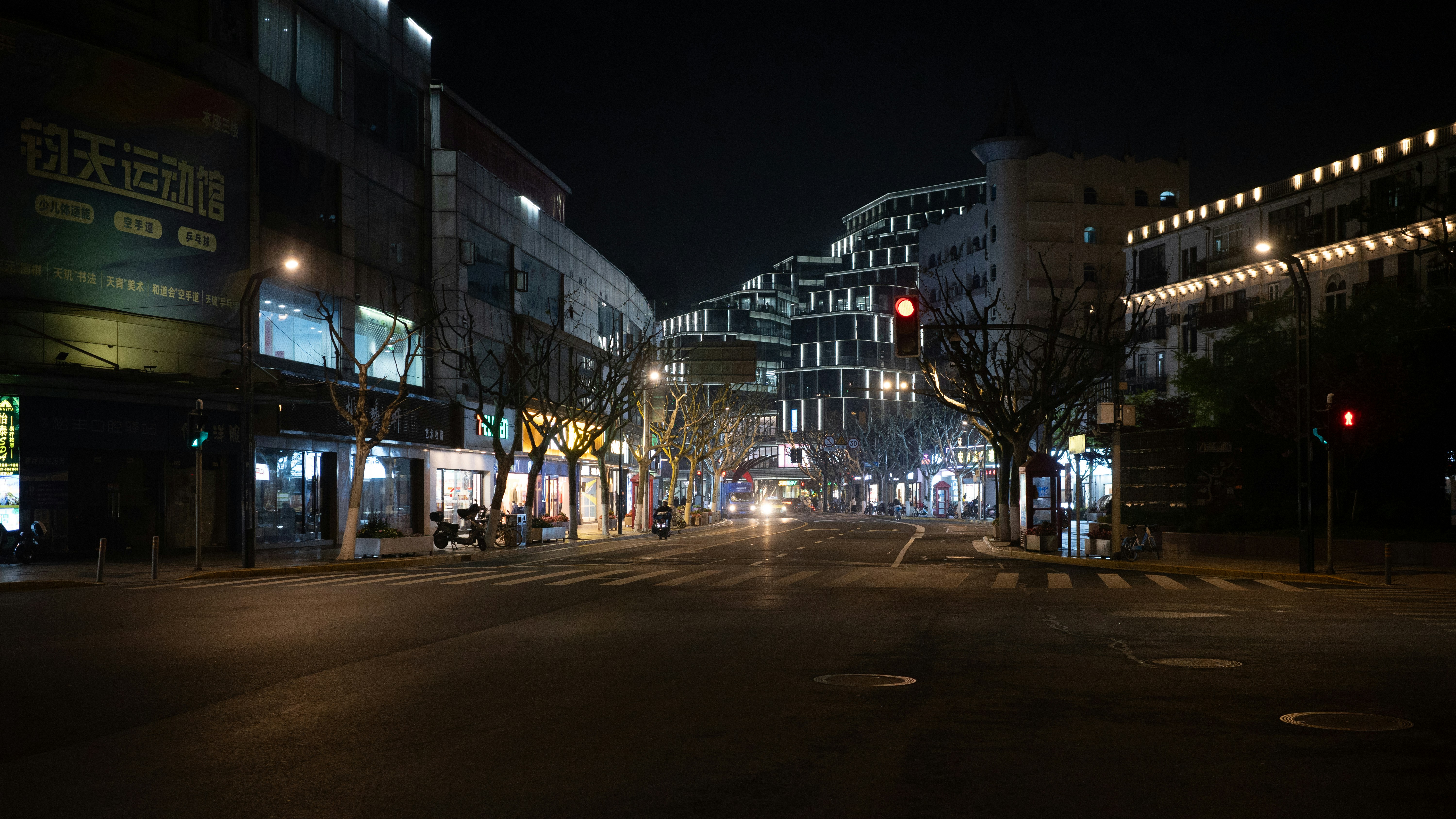 City street at night with illuminated buildings and lights.