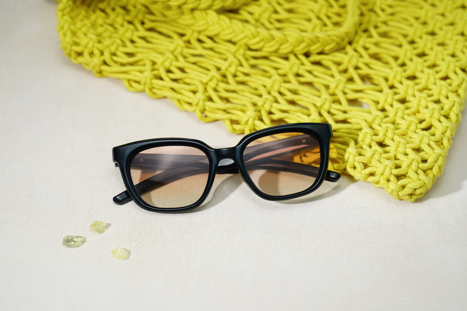 Black sunglasses beside a woven lime-green bag