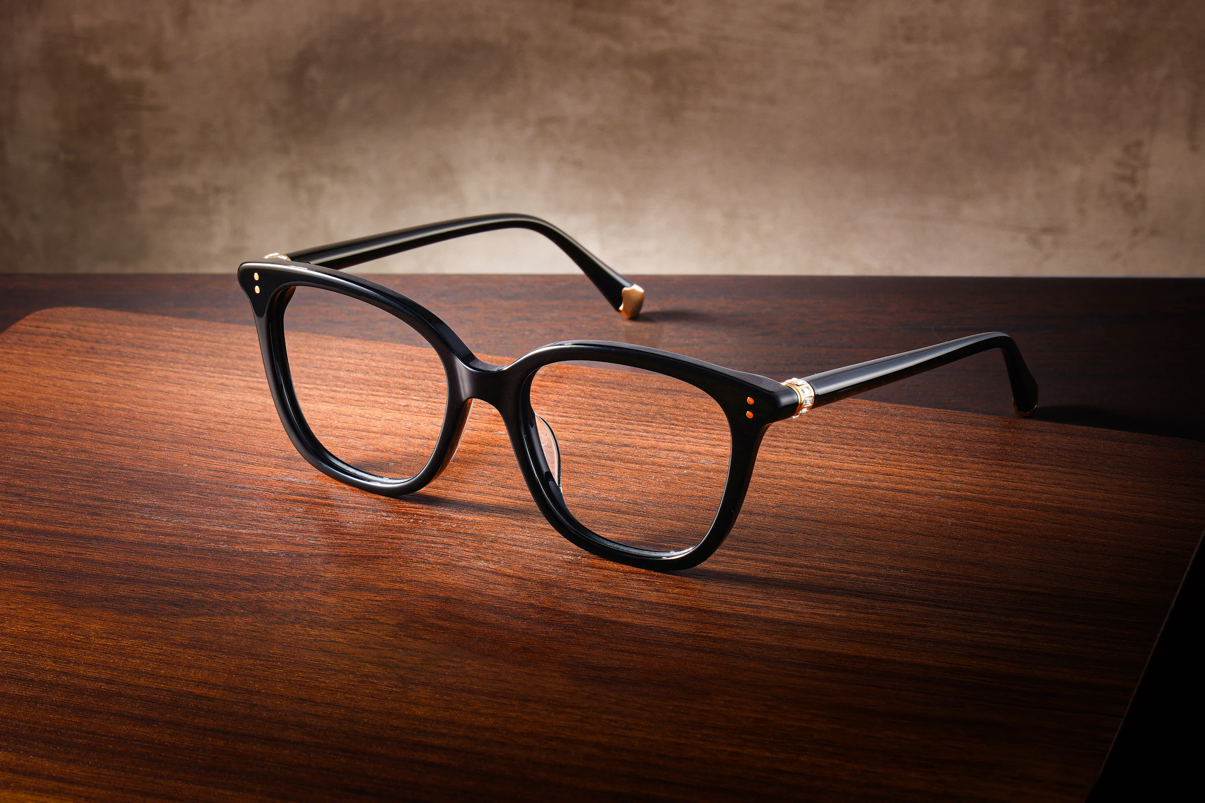 Monture noire en acétate sur table en bois