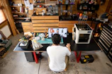 Man working at a desk with 3D printer.