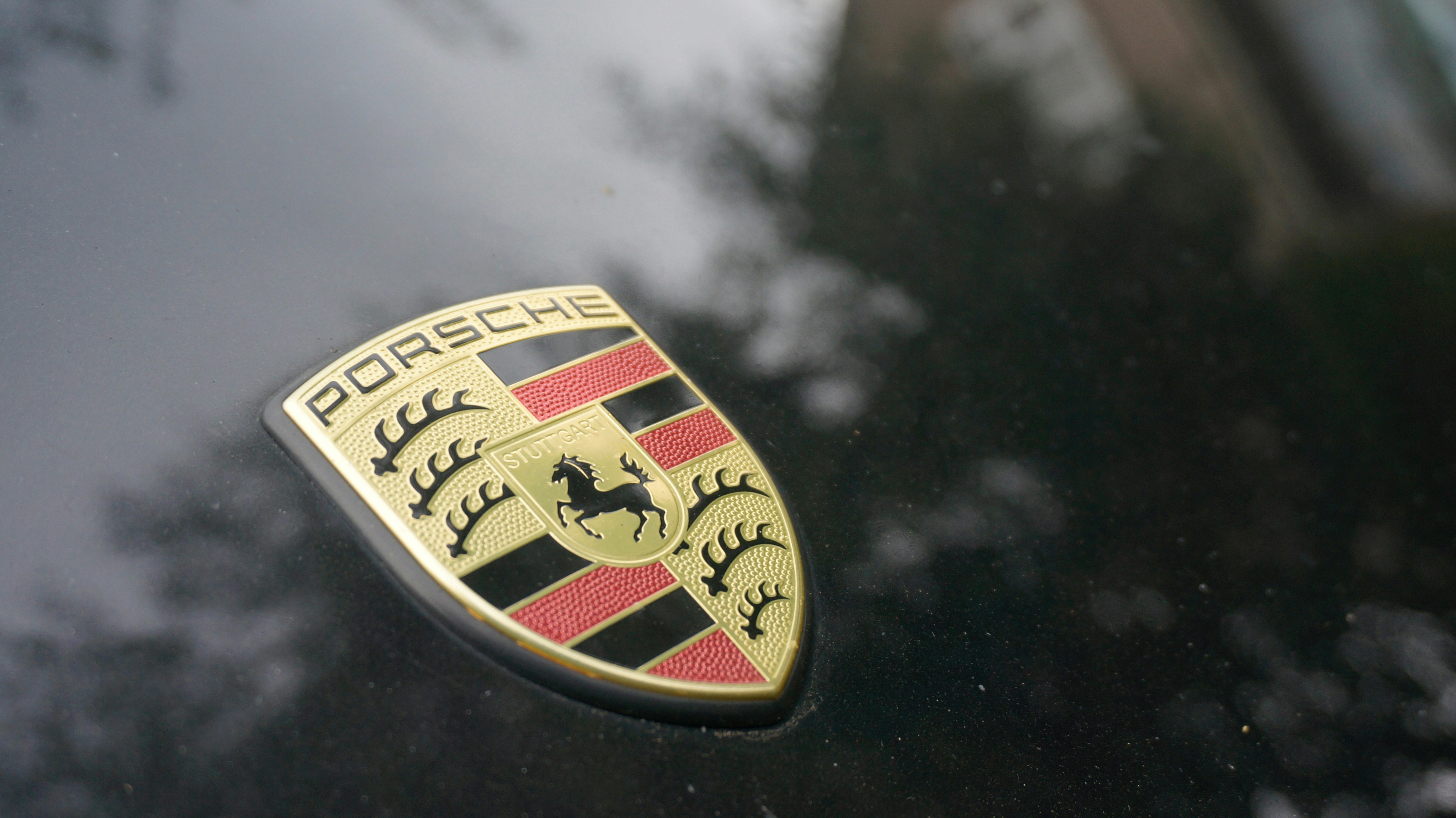 Porsche emblem on a dark car hood