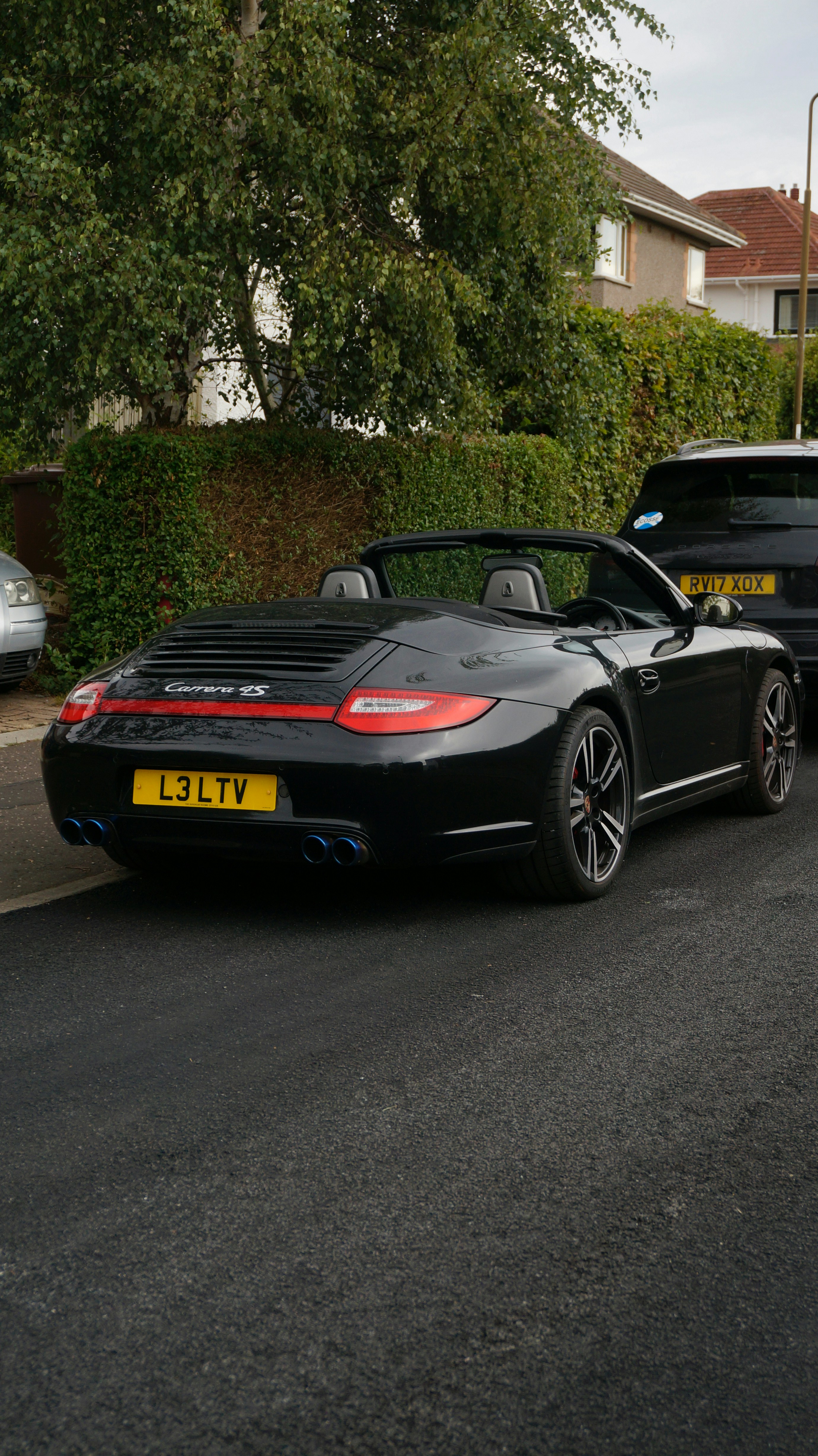 Black convertible porsche carrera s parked on asphalt