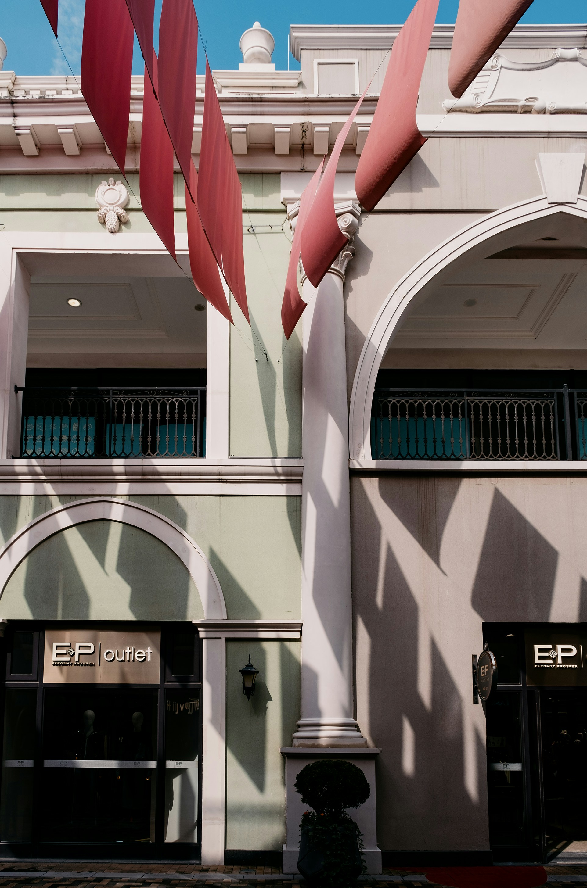 Pink ribbons hang in front of a building.