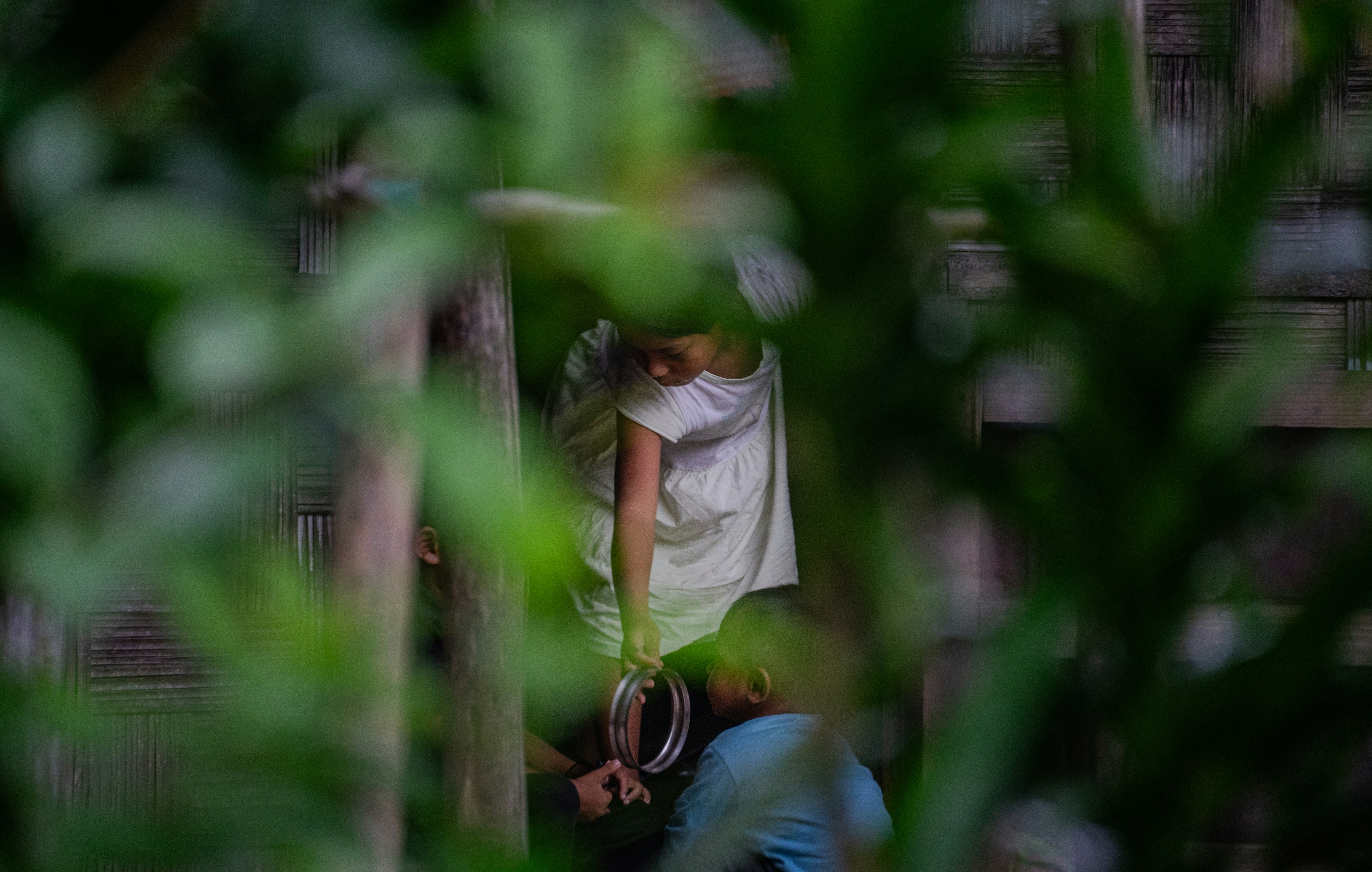 Children playing on gymnastic rings outdoors.