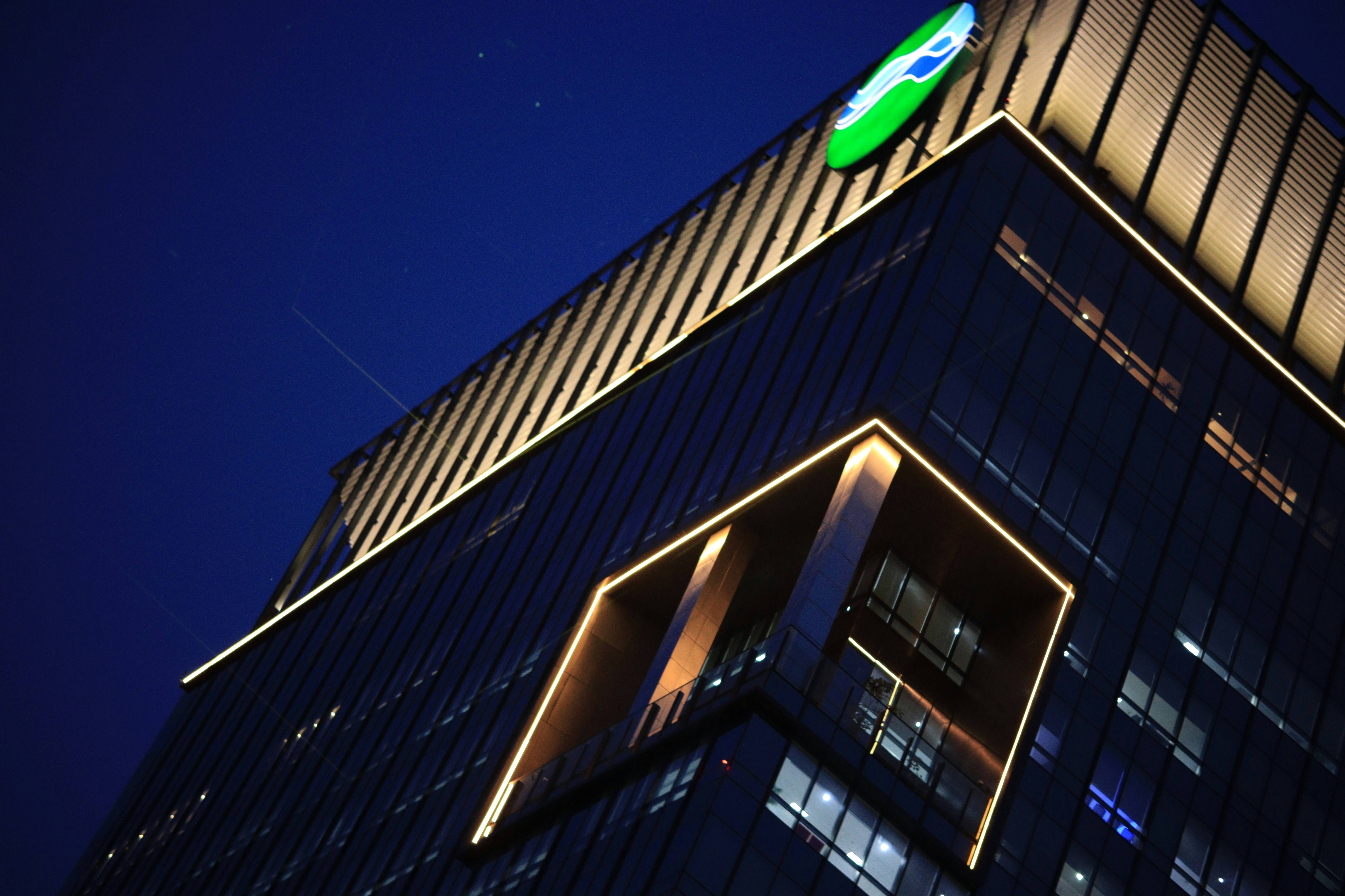 Modern building with illuminated logo at night