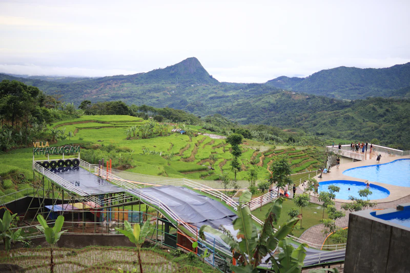 The pool terrace looking out across terraced slopes to a sharp green peak