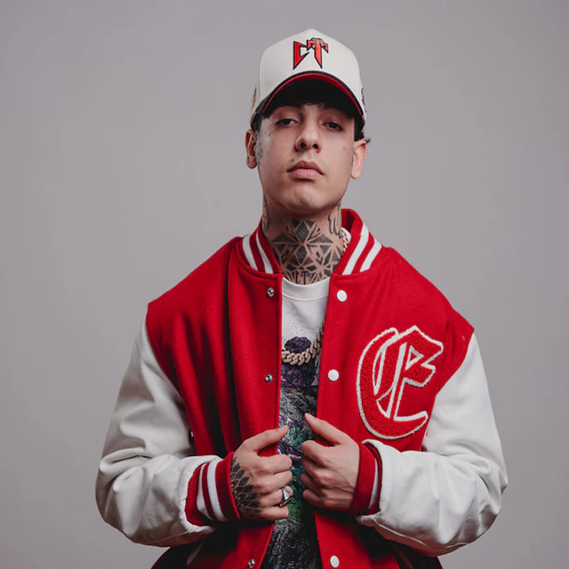 A young man in a baseball cap and a varsity jacket