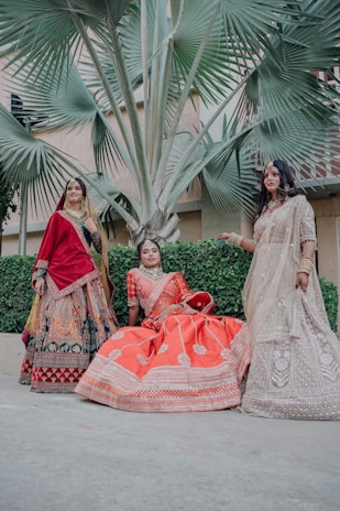 Three women in traditional indian wedding attire.
