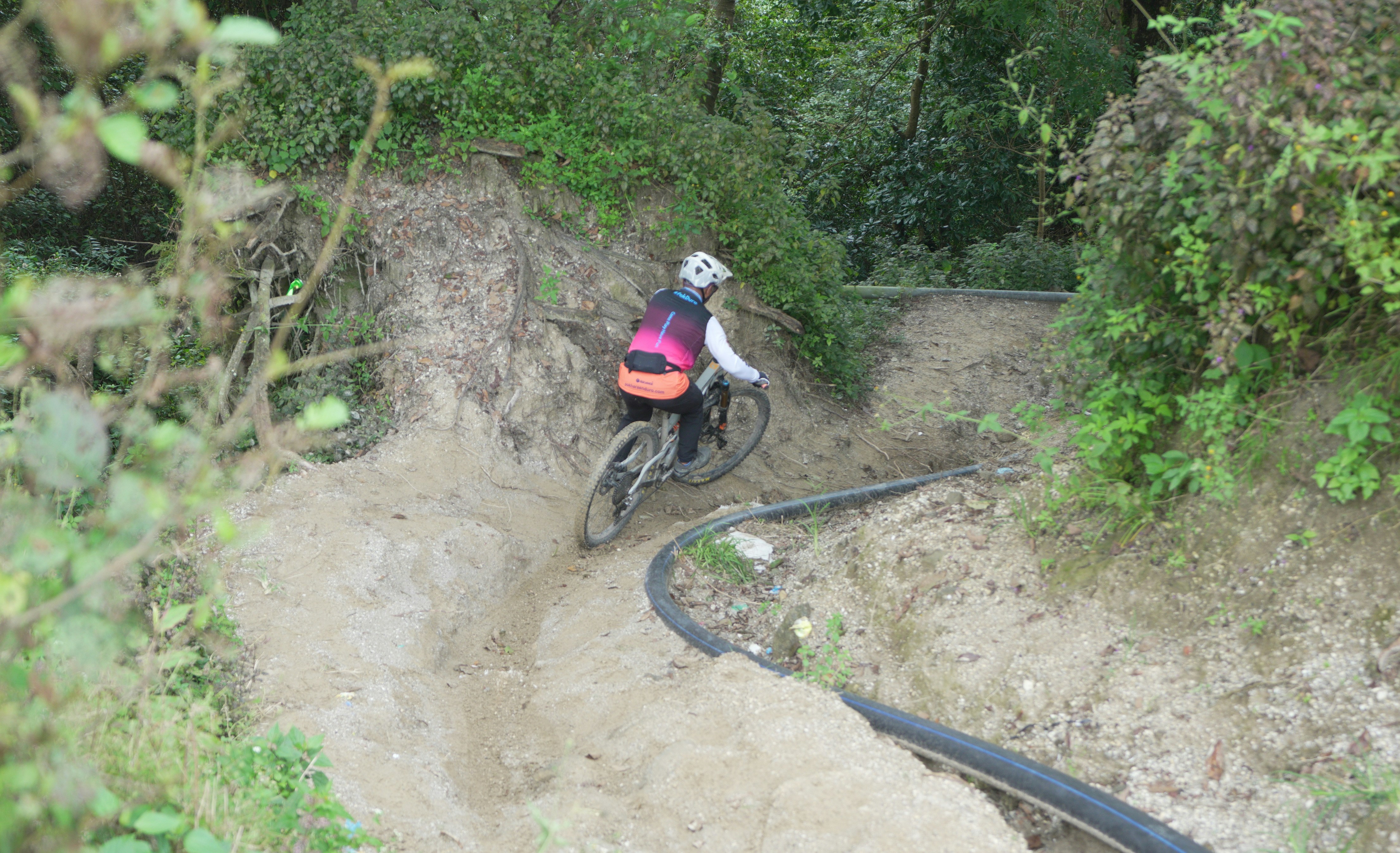 Mountain biker descends a steep, dusty trail.