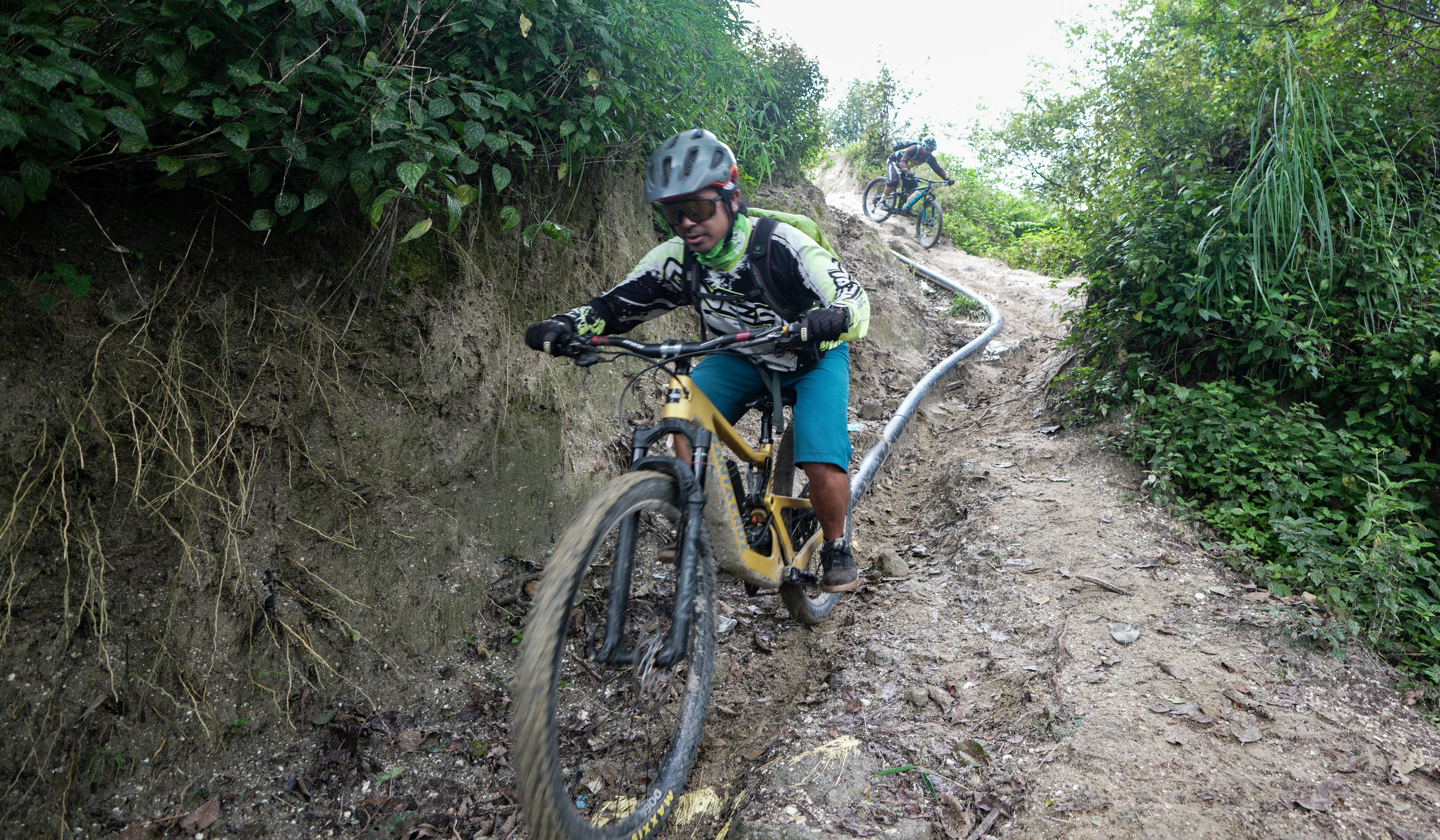 Mountain biker riding down a steep, rocky trail.