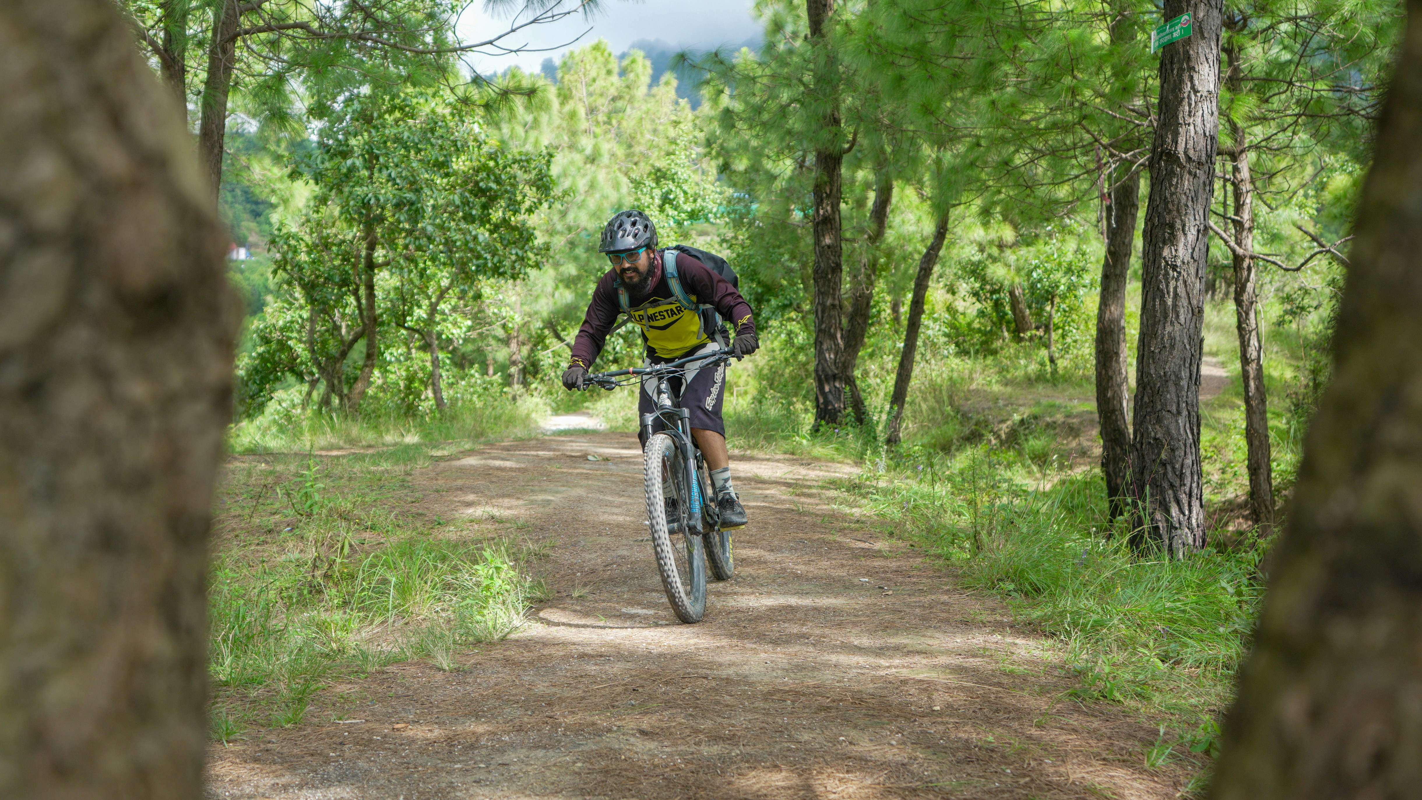 Man rides a mountain bike on a dirt path.