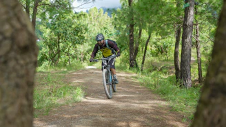 Man rides a mountain bike on a dirt path.