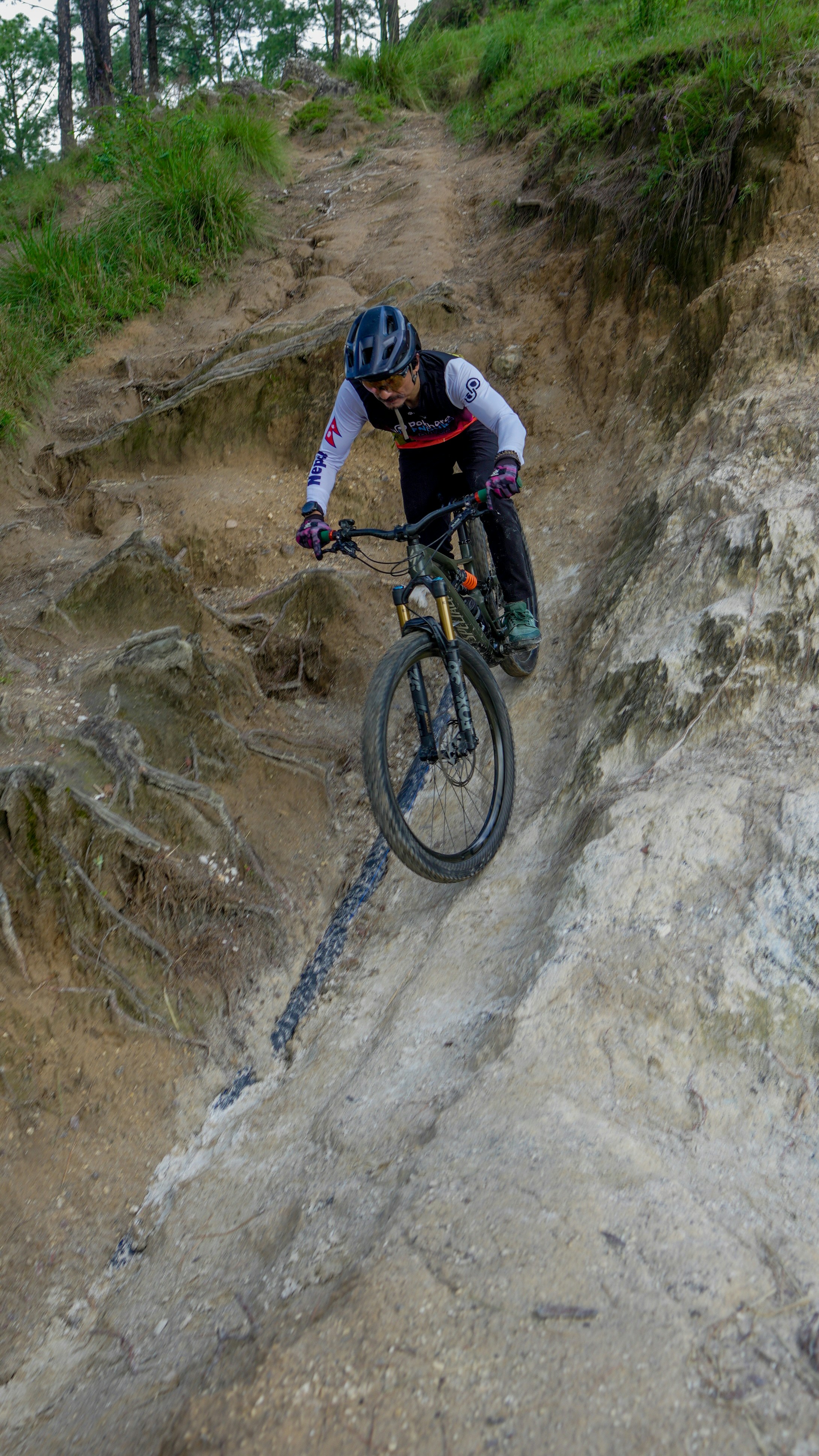 Mountain biker descends a steep, rocky trail.