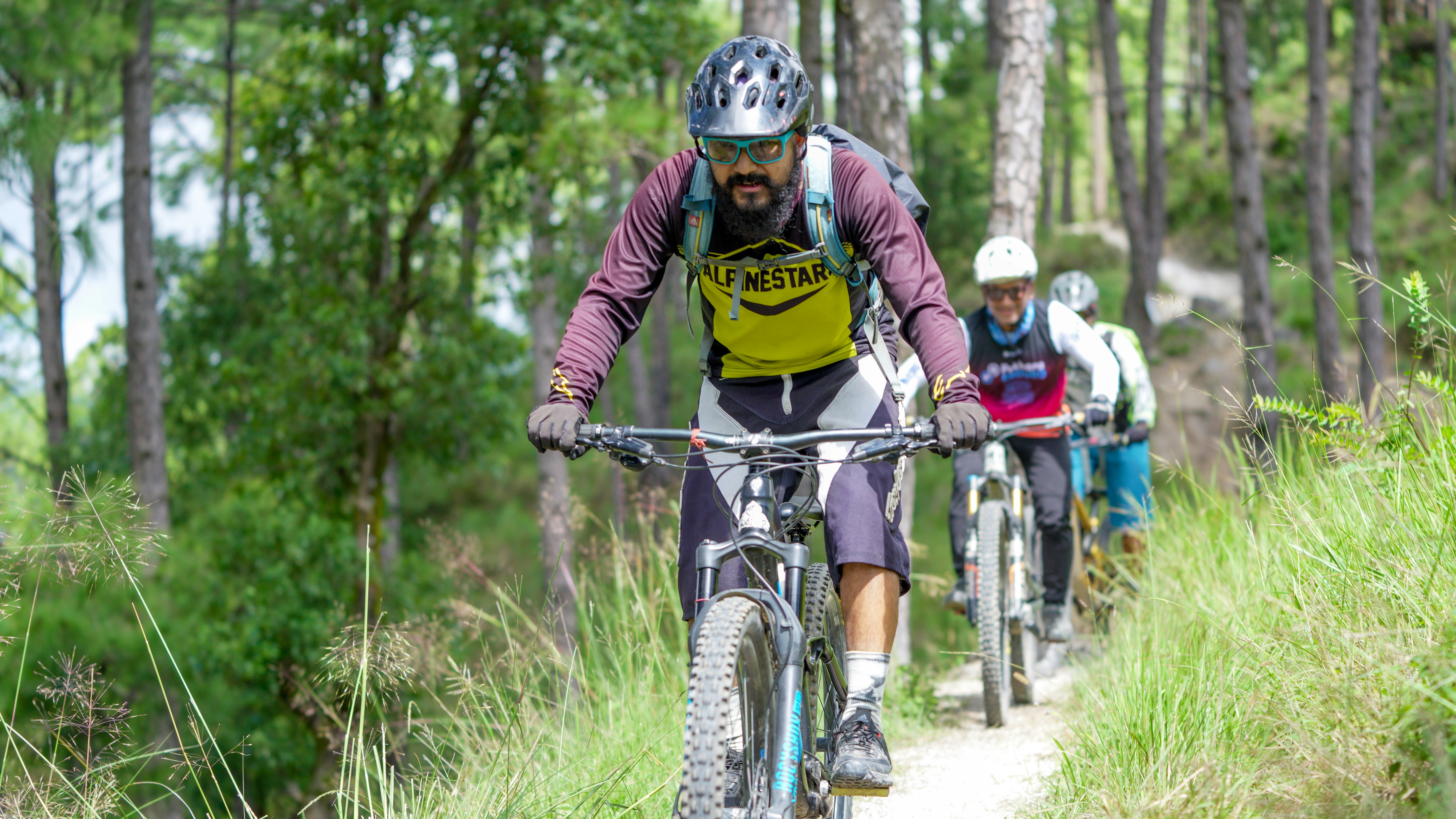 Men riding mountain bikes on a dirt path.