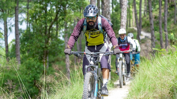 Men riding mountain bikes on a dirt path.