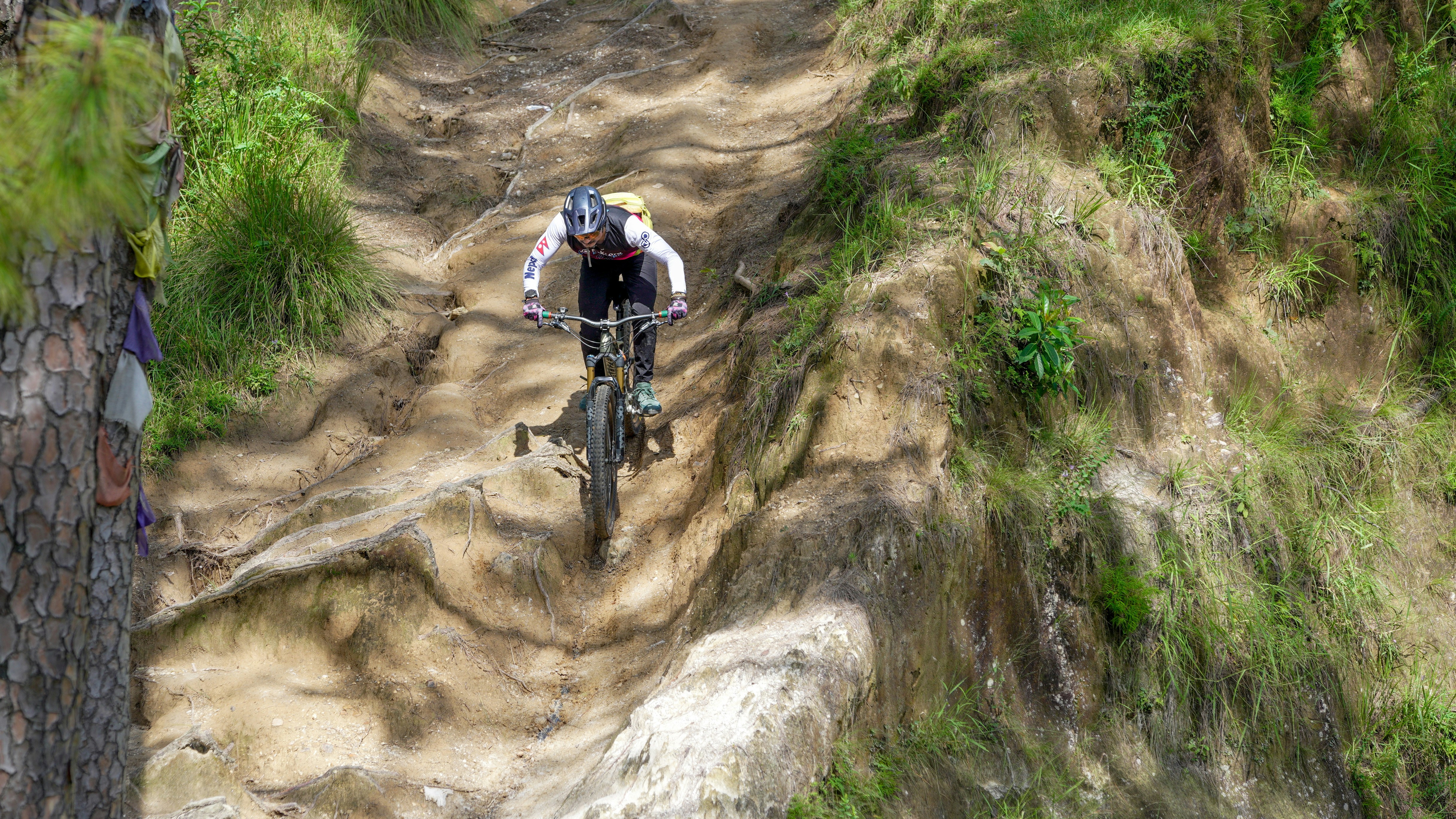 A person rides a bicycle down a steep, rocky path.