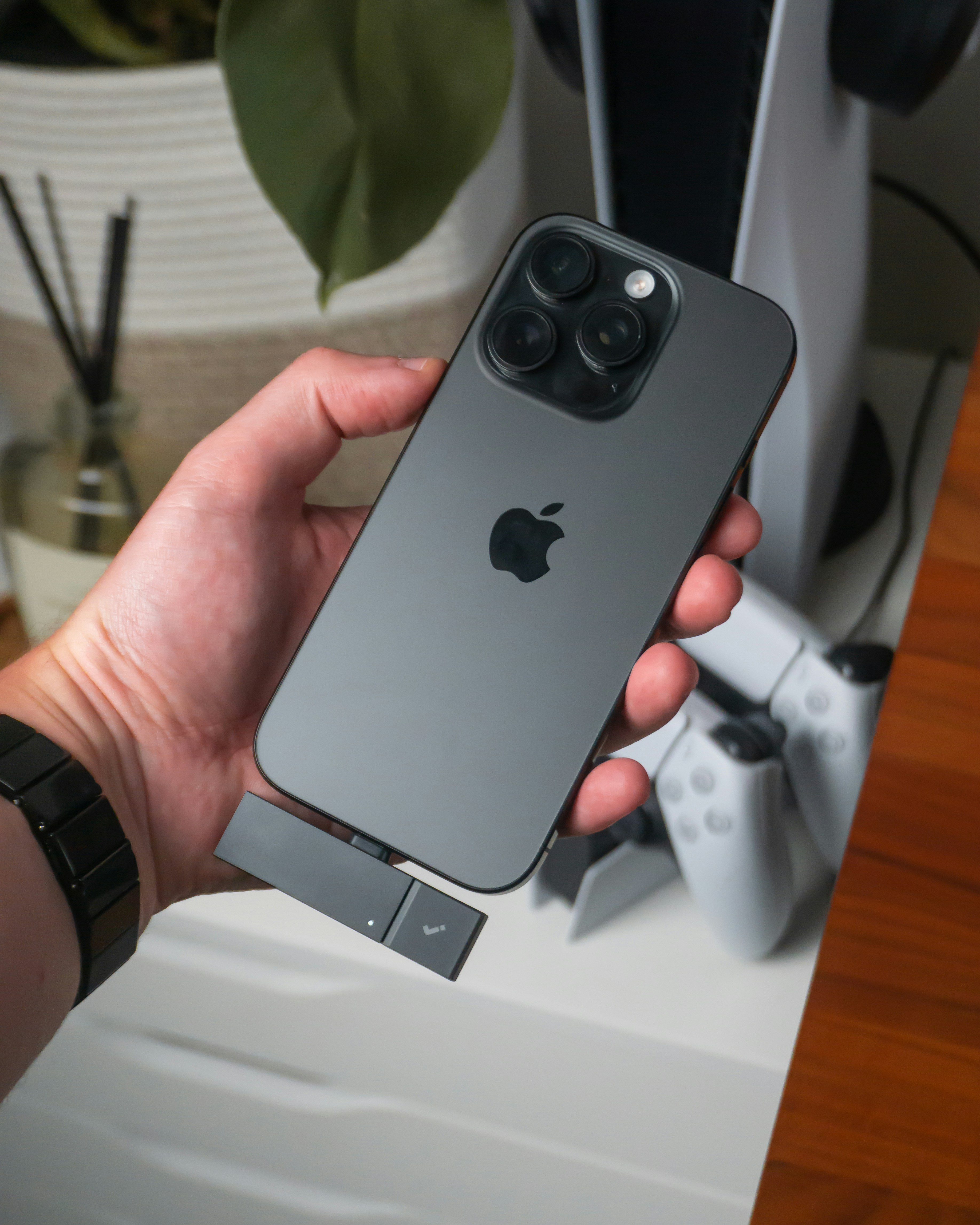Hand holding iPhone with usb-c adapter and game controller