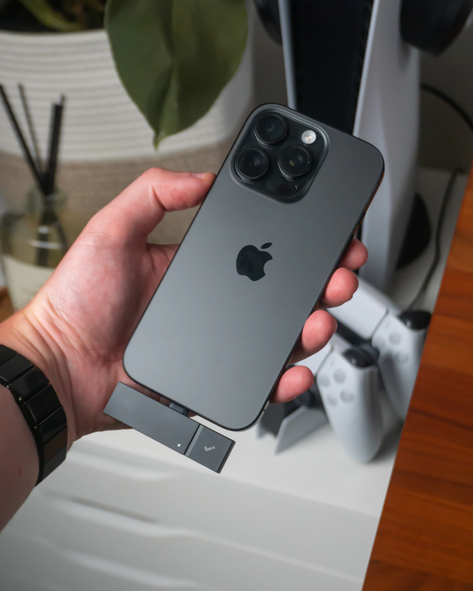 Hand holding a smartphone with a USB-C accessory attached
