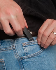 Person putting a usb drive into jeans pocket