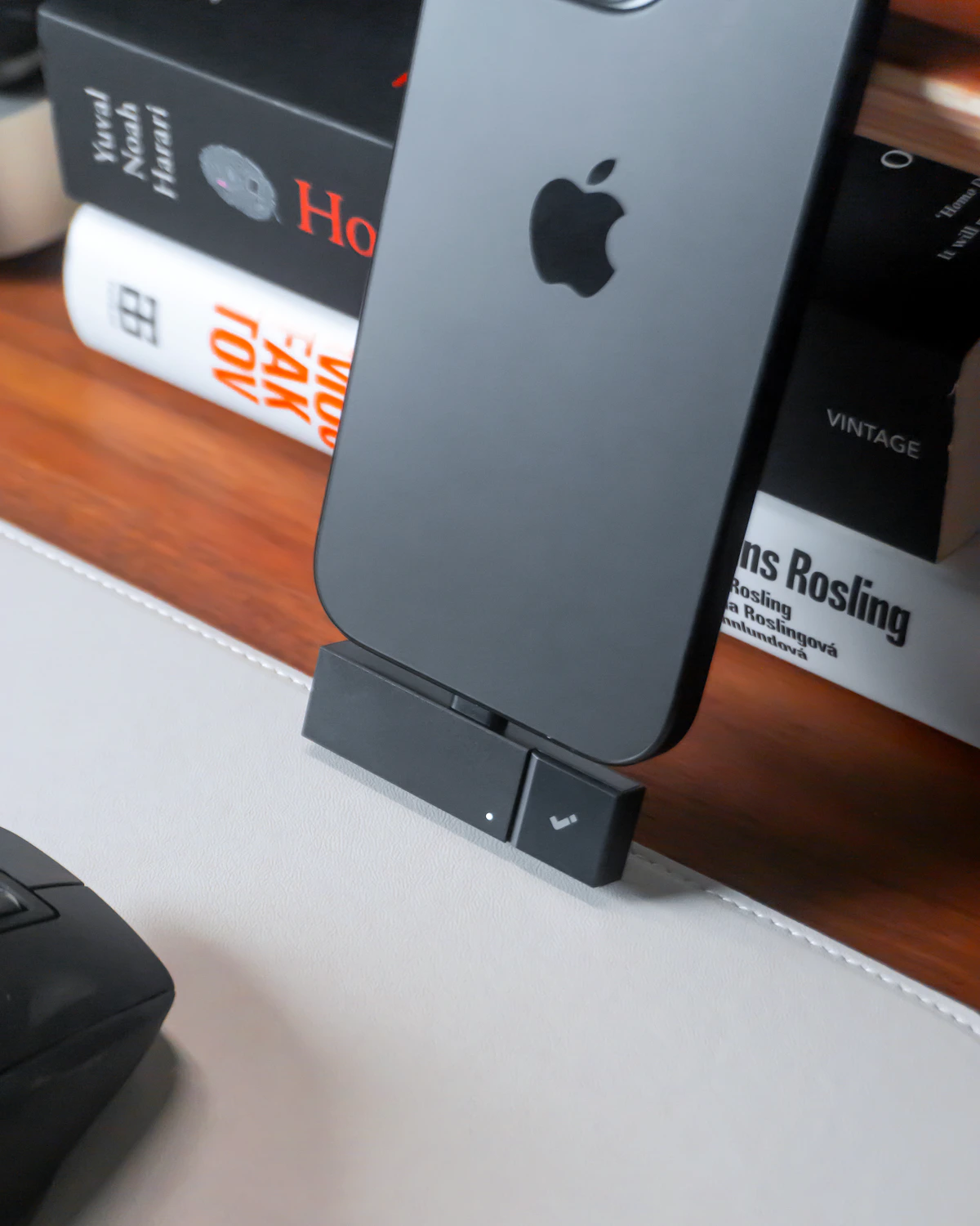 Smartphone positioned on a compact charging stand in a home workspace