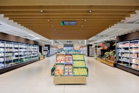 A well-lit grocery store aisle with produce displays.