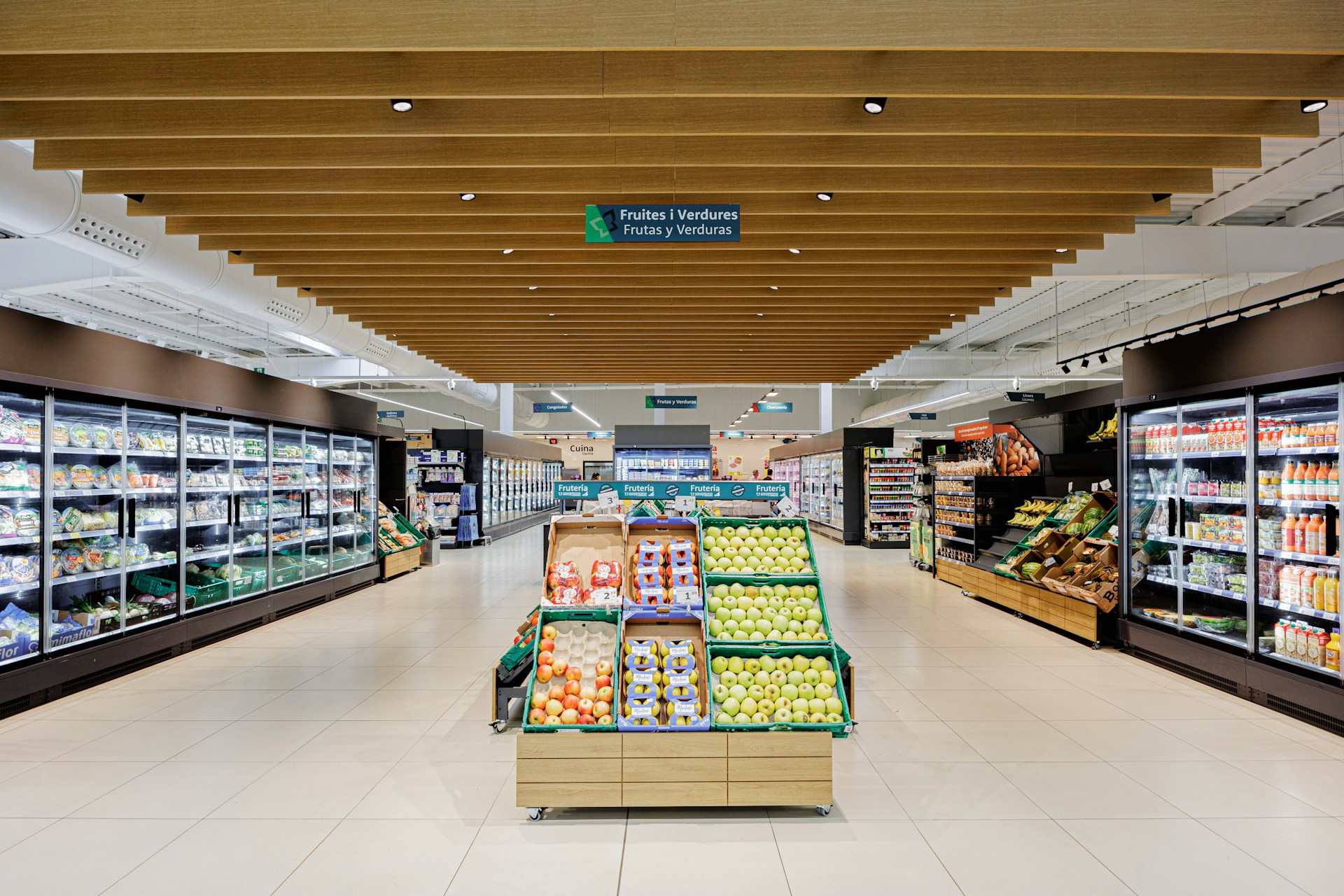 A well-lit grocery store aisle with produce displays.