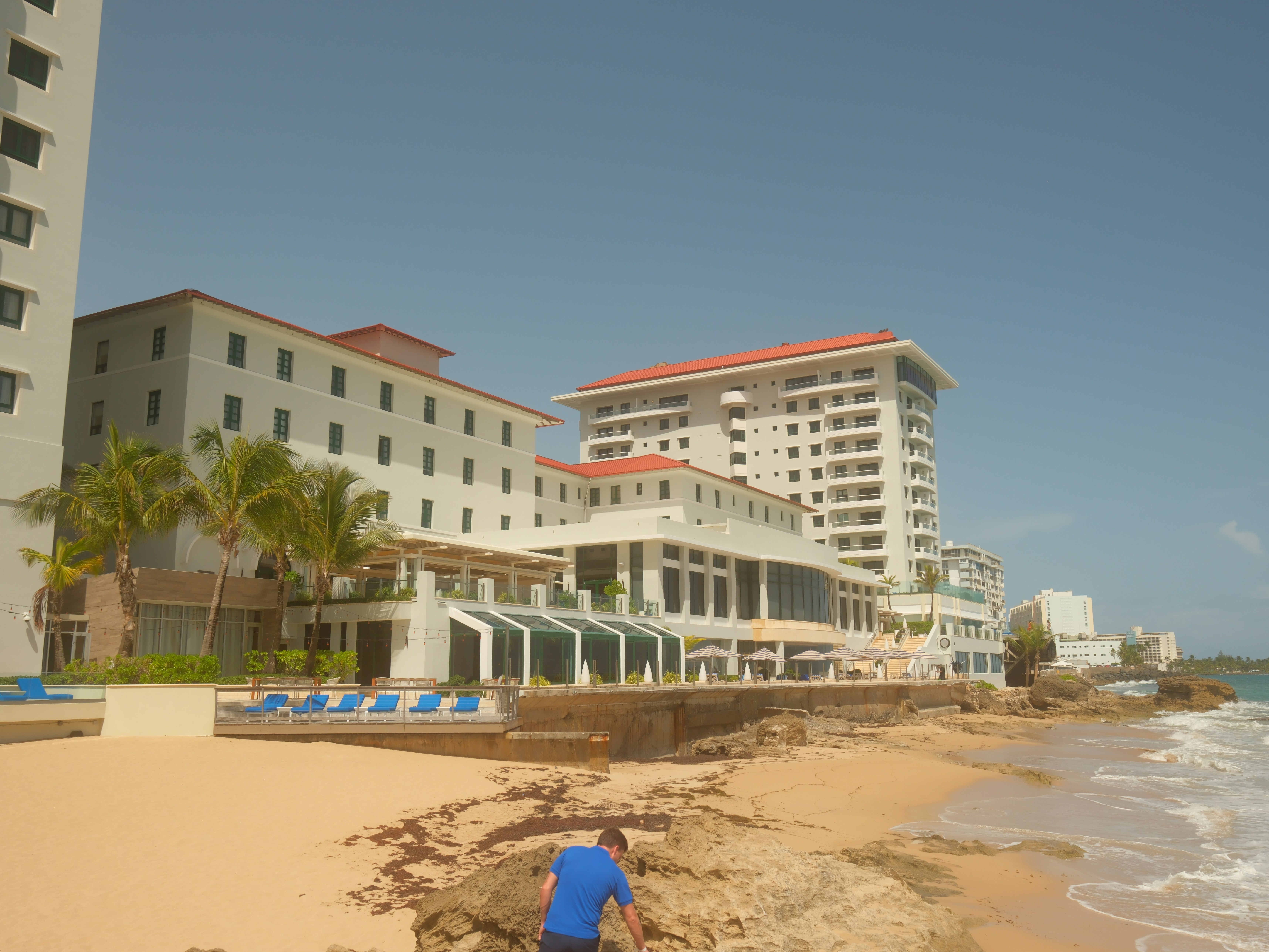 Beachfront resort buildings with palm trees and ocean