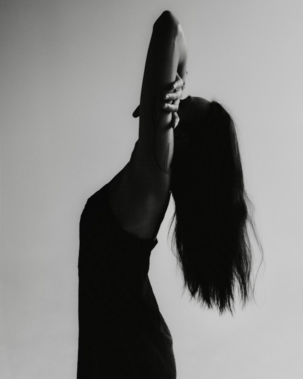 Silhouette of a woman with long hair arching back.