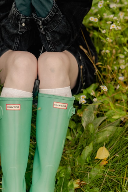 Hunter with rifle on shooting sticks in open western terrain