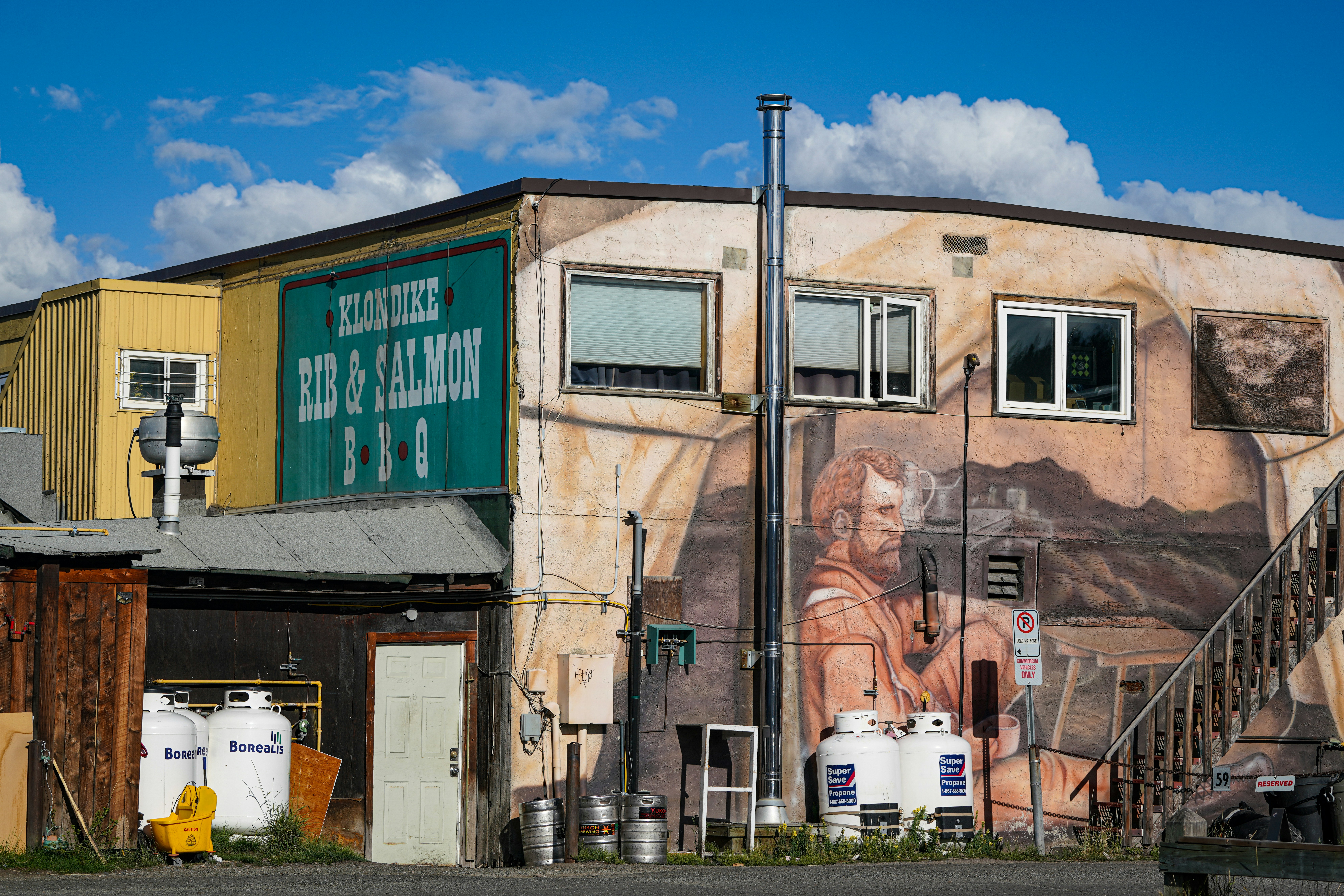 Gebäude mit Wandgemälde und "Red & Salmon BBQ"-Schild.