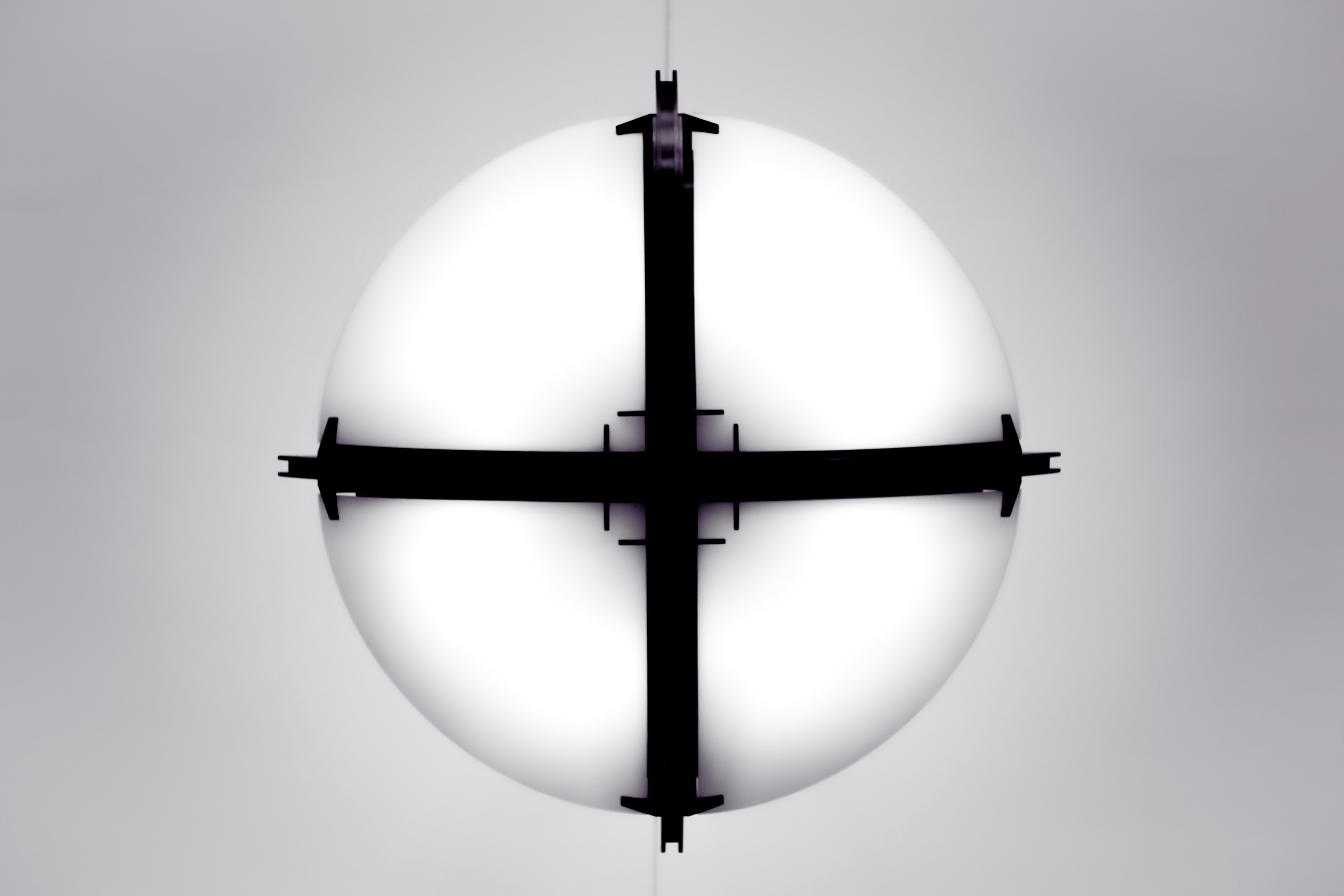 A white sphere with black crossbars against a gray background