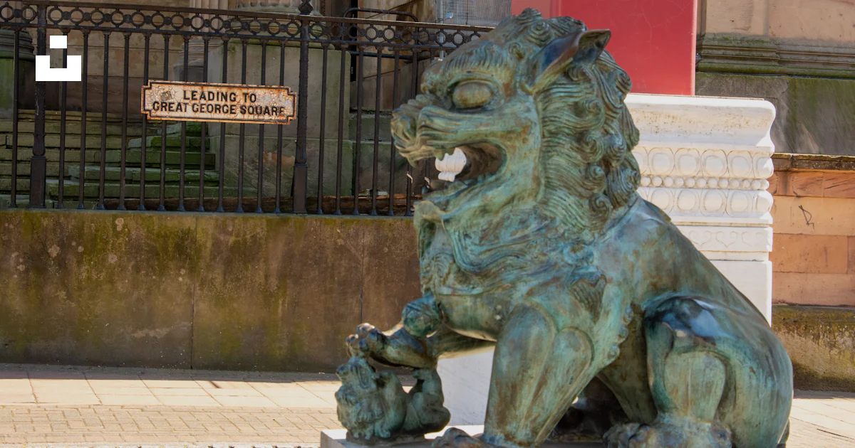 Lion Building Sign A weathered bronze lion statue guards a building entrance. photo – Free ...