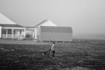 Person walking a dog in a field
