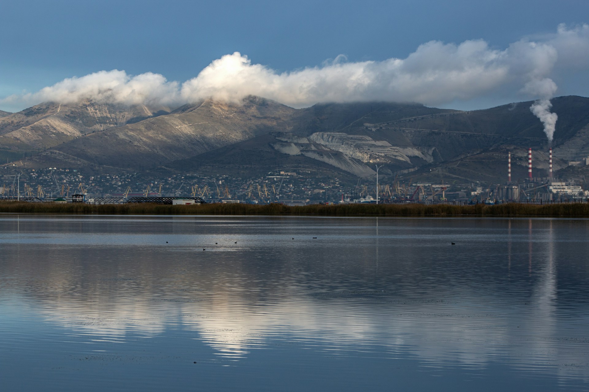 Smoke rising from industrial chimneys near mountains